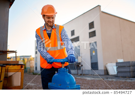 Construction worker checking industrial manufacturer gate valve 85494727