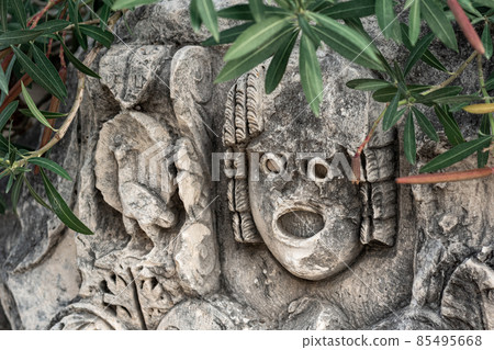 antique stone-cut mask among vegetation in the ruins of the ancient city of Myra, Turkey antique stone-cut mask among vegetation in the ruins of the ancient city of Myra, Turkey 85495668