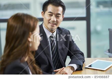 asian business man and woman having a conversation in office 85498887
