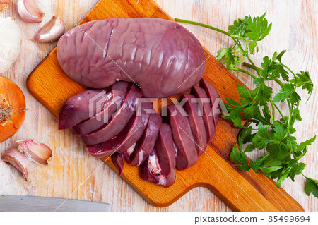Raw pork kidneys on wooden table 85499694