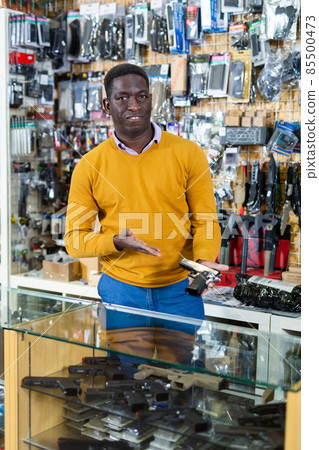 Man with pistol in arms shop Man with pistol in arms shop 85500473