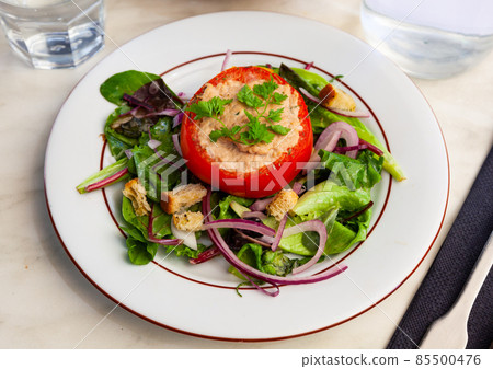 Deliciously tomato stuffed with tuna on a pillow of salad Deliciously tomato stuffed with tuna on a pillow of salad 85500476