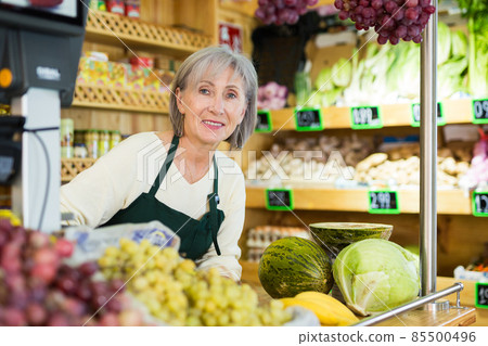 Portrait of a positive female salesperson at the checkout counter at grocery supermarket 85500496