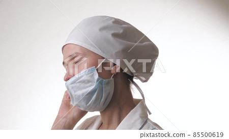 The tired doctor takes off the mask. Medical worker. Nurse at the hospital. Protection against infections, bacteria, pollution. Air filtration. Mask mode. Pandemic. 85500619