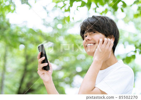 Smartphone earphones young men outdoor fresh green 85502270