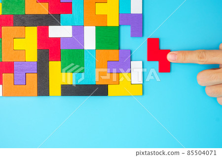 Hand connecting colorful wood puzzle pieces on blue background, geometric shape block. Concepts of logical thinking, Conundrum, solutions, rational, strategy, world logic day and Education Hand connecting colorful wood puzzle pieces on blue background, geometric shape block. Concepts of logical thinking, Conundrum, solutions, rational, strategy, world logic day and Education 85504071