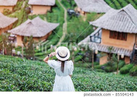 Happy tourist woman in white dress enjoy beautiful Tea garden.Traveler visiting in Ban Rak Thai village, Mae Hong Son, Thailand. travel, vacation and holiday concept 85504143