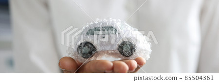 Female agent is holding toy car packed in bubble plastic bag 85504361