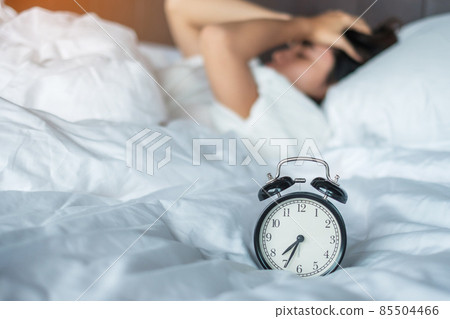 Asian woman lying in bed at morning with retro alarm clock, young female sleep in bedroom at home. restless, insomnia sleeping, worried and stressed concepts Asian woman lying in bed at morning with retro alarm clock, young female sleep in bedroom at home. restless, insomnia sleeping, worried and stressed concepts 85504466
