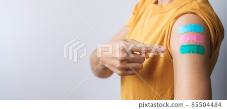 woman showing plaster after receiving covid 19 vaccine. Vaccination, herd immunity, side effect, booster dose, vaccine passport and Coronavirus pandemic 85504484