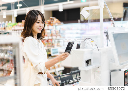 Young woman using smartphone payment at supermarket 85505072
