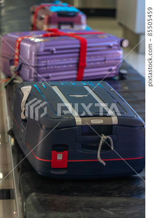 Vertical photo of suitcase on luggage conveyor belt 85505459