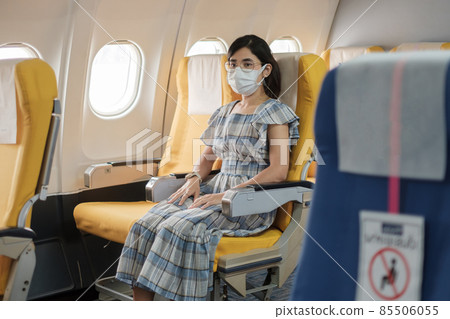 woman wearing protective face mask sitting in airplane or public transportation, protection Coronavirus disease infection, tourist ready to travel. Next Normal, tourism and reopening concept woman wearing protective face mask sitting in airplane or public transportation, protection Coronavirus disease infection, tourist ready to travel. Next Normal, tourism and reopening concept 85506055