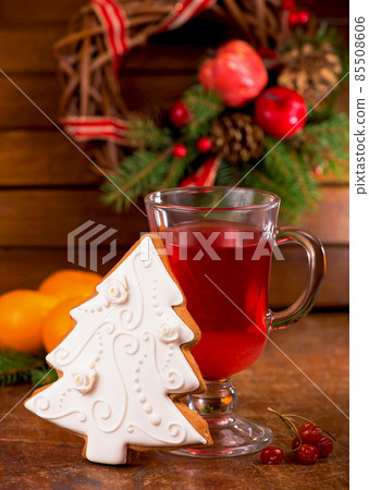 a cup of tea with spices and viburnum berries and Christmas gingerbread with a wreath of evergreen branches a cup of tea with spices and viburnum berries and Christmas gingerbread with a wreath of evergreen branches 85508606