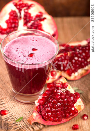 Juicy pomegranate and a glass of pomegranate juice Beautiful composition with juicy pomegranates, on old wooden table Juicy pomegranate and a glass of pomegranate juice Beautiful composition with juicy pomegranates, on old wooden table 85508608