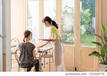 戴面具的女店員為顧客提供飲料 85509778