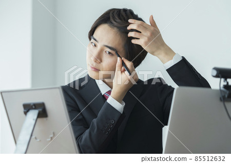 穿西裝的年輕人照鏡子畫眉毛的形象 穿西裝的年輕人照鏡子畫眉毛的形象 85512632