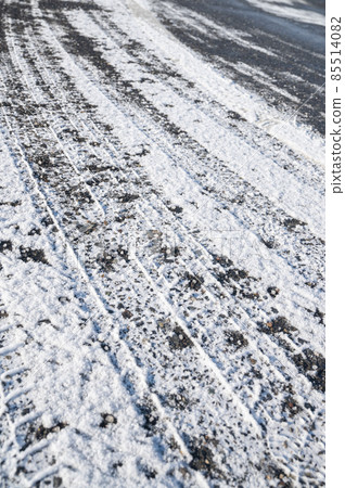 Snowy road with tire marks 85514082