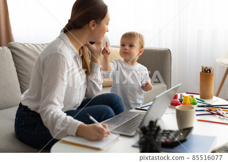 Moms can balance work and family. Young mother multitasking and working from home and spending time with son Moms can balance work and family. Young mother multitasking and working from home and spending time with son 85516077