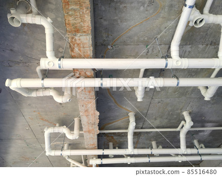 PENANG, MALAYSIA -JANUARY 5, 2021: Sewerage pipes from the toilet above are interconnected under the floor soffit. Installed in gradient and gravity flow. Channeled to the main sewer line. PENANG, MALAYSIA -JANUARY 5, 2021: Sewerage pipes from the toilet above are interconnected under the floor soffit. Installed in gradient and gravity flow. Channeled to the main sewer line. 85516480