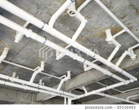 PENANG, MALAYSIA -JANUARY 5, 2021: Sewerage pipes from the toilet above are interconnected under the floor soffit. Installed in gradient and gravity flow. Channeled to the main sewer line.  85516483