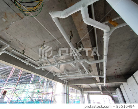 PENANG, MALAYSIA -JANUARY 5, 2021: Sewerage pipes from the toilet above are interconnected under the floor soffit. Installed in gradient and gravity flow. Channeled to the main sewer line.  85516494