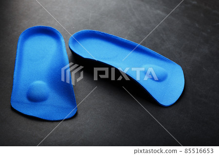 Orthopedic insoles for correction of pronation of the foot on a dark background. 85516653