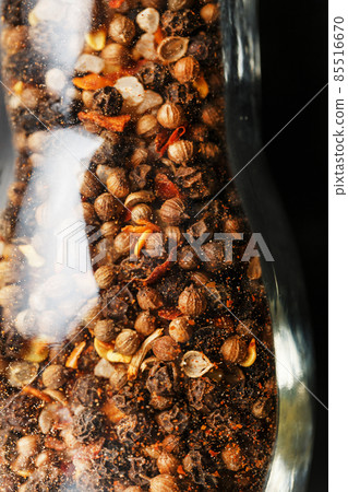 A mixture of peppercorns seasoning and salt in a transparent mill close-up A mixture of peppercorns seasoning and salt in a transparent mill close-up 85516670