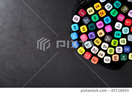A set of markers for drawing in different colors for sketching with markings in a bag on a black background. A set of markers for drawing in different colors for sketching with markings in a bag on a black background. 85516693