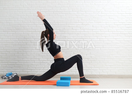 the girl conducts a workout to stretch her body and sit on the splits the girl conducts a workout to stretch her body and sit on the splits 85516787