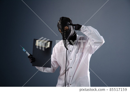 doctor in a dressing gown, in a plague doctor's mask, is vaccinating 85517159