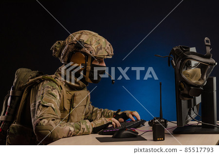 soldier sitting at a computer is conducting a cyber war soldier sitting at a computer is conducting a cyber war 85517793