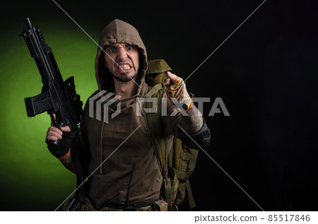 man Stalker with a gun with an optical sight and a backpack on a dark background with emotions looking, aiming, watching, sneaking 85517846