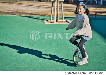 Children riding a unicycle Children riding a unicycle 85518384