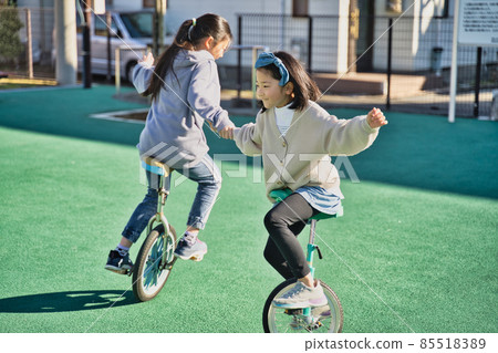 Children riding a unicycle Children riding a unicycle 85518389