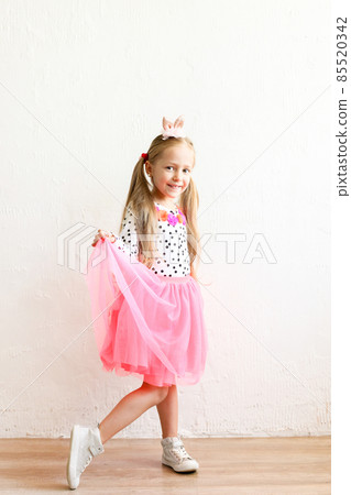 Smiling girl with bunny ears, white wall copy space background. 85520342