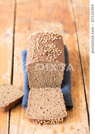 Famous russian rye sourdough bread - Borodinskiy with cardamom and malt on a wooden background. 85520364