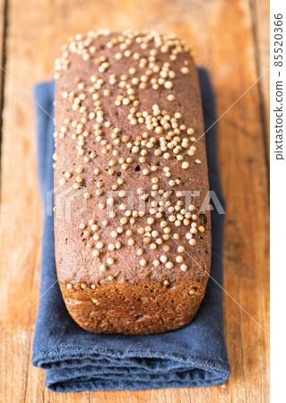 Famous russian rye sourdough bread - Borodinskiy with cardamom and malt on a wooden background. 85520366