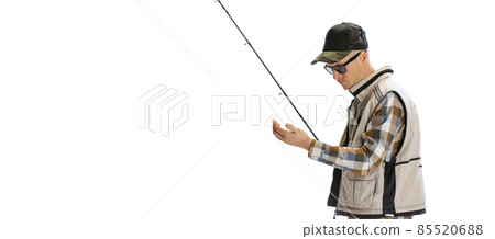 Portrait of young man, professional fisherman with fishing rod, spinning and equipment going to river isolated over white studio background Portrait of young man, professional fisherman with fishing rod, spinning and equipment going to river isolated over white studio background 85520688