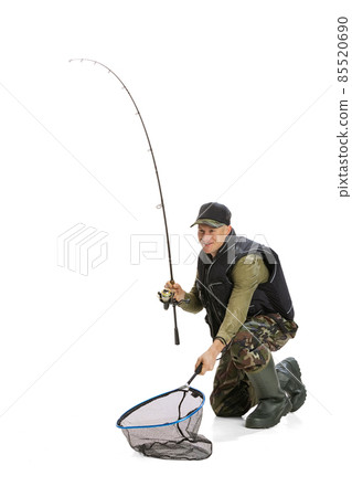 Portrait of young man, professional fisherman with fishing rod, spinning and equipment sitting isolated over white studio background Portrait of young man, professional fisherman with fishing rod, spinning and equipment sitting isolated over white studio background 85520690