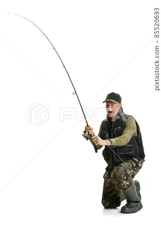 Portrait of young man, professional fisherman with fishing rod, spinning and equipment going to river isolated over white studio background Portrait of young man, professional fisherman with fishing rod, spinning and equipment going to river isolated over white studio background 85520693