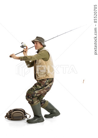 Portrait of young man, professional fishman with fishing rod, spinning and equipment going to river isolated over white studio background Portrait of young man, professional fishman with fishing rod, spinning and equipment going to river isolated over white studio background 85520705