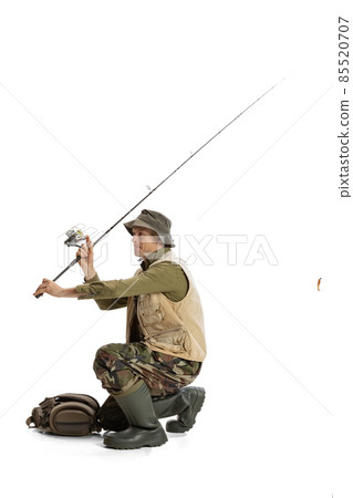 Portrait of young man, professional fishman with fishing rod, spinning and equipment going to river isolated over white studio background Portrait of young man, professional fishman with fishing rod, spinning and equipment going to river isolated over white studio background 85520707