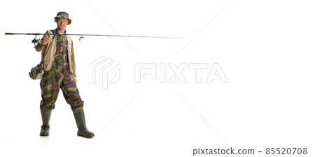 Portrait of young man, professional fisherman with fishing rod, spinning and equipment going to river isolated over white studio background Portrait of young man, professional fisherman with fishing rod, spinning and equipment going to river isolated over white studio background 85520708