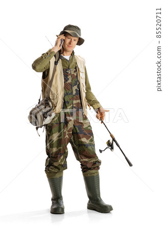 Portrait of young man, professional fisherman with fishing rod, spinning and equipment going to river isolated over white studio background Portrait of young man, professional fisherman with fishing rod, spinning and equipment going to river isolated over white studio background 85520711
