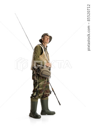 Portrait of young man, professional fishman with fishing rod, spinning and equipment going to river isolated over white studio background Portrait of young man, professional fishman with fishing rod, spinning and equipment going to river isolated over white studio background 85520712