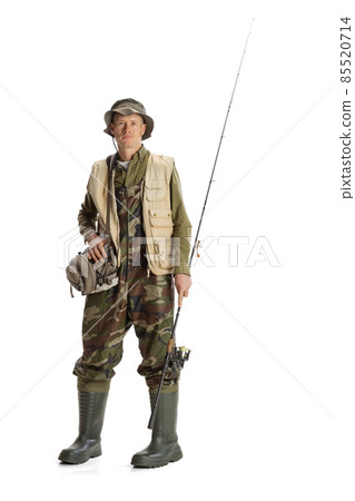 Portrait of young man, professional fishman with fishing rod, spinning and equipment going to river isolated over white studio background Portrait of young man, professional fishman with fishing rod, spinning and equipment going to river isolated over white studio background 85520714