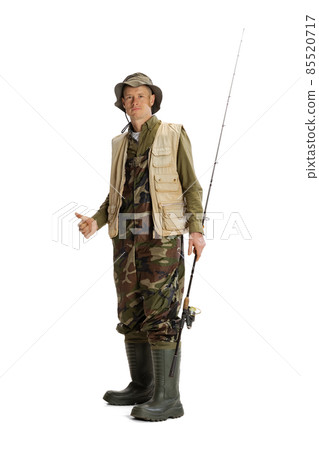 Portrait of young man, professional fisherman with fishing rod, spinning and equipment going to river isolated over white studio background Portrait of young man, professional fisherman with fishing rod, spinning and equipment going to river isolated over white studio background 85520717