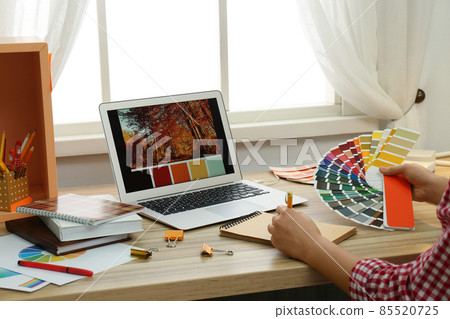 Female designer working at wooden table indoors, closeup Female designer working at wooden table indoors, closeup 85520725