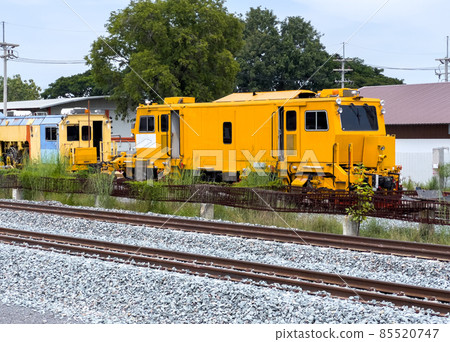 The maintenance train vehicle used for laying railway sleepers is parked in the construction site. 85520747